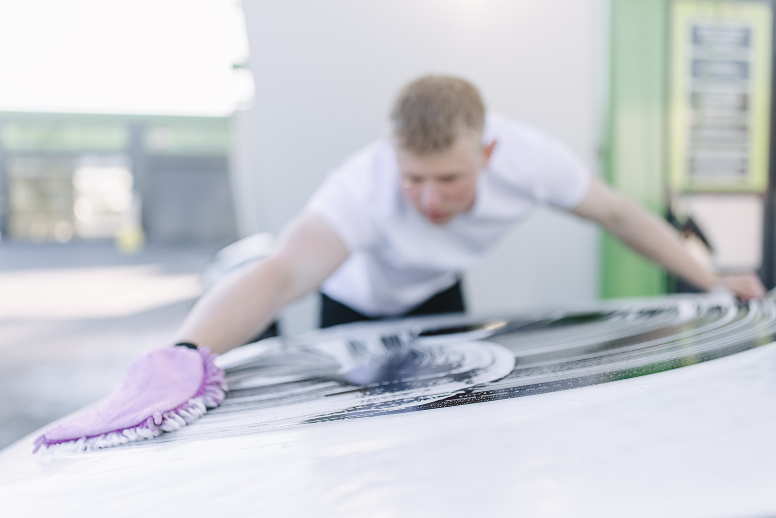 Autopfleger wäscht Fahrzeugdach mit Waschhandschuh und Schaum – professionelle Handwäsche bei Max UP
