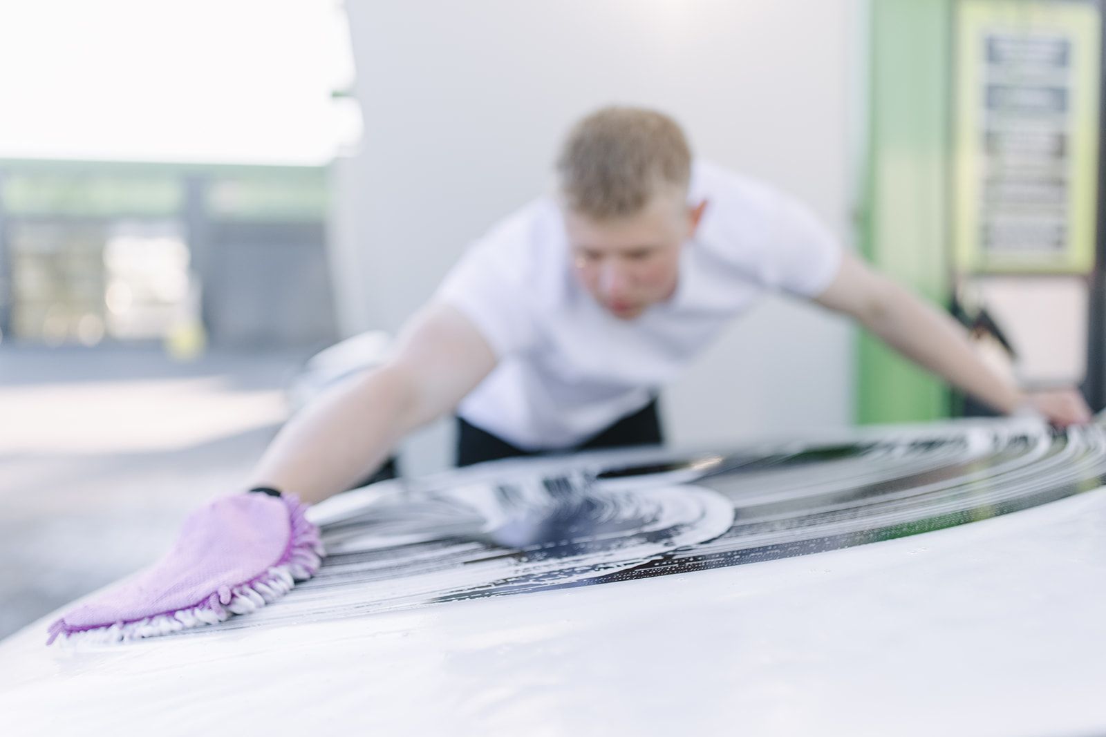 Autopfleger wäscht Fahrzeugdach mit Waschhandschuh und Schaum – professionelle Handwäsche bei Max UP