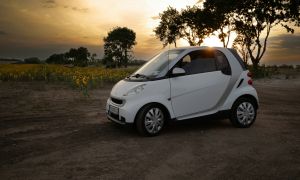 Weißes Auto vor Sonnenblumenfeld bei Sonnenuntergang – stimmungsvolle Fahrzeugaufnahme in ländlicher Umgebung